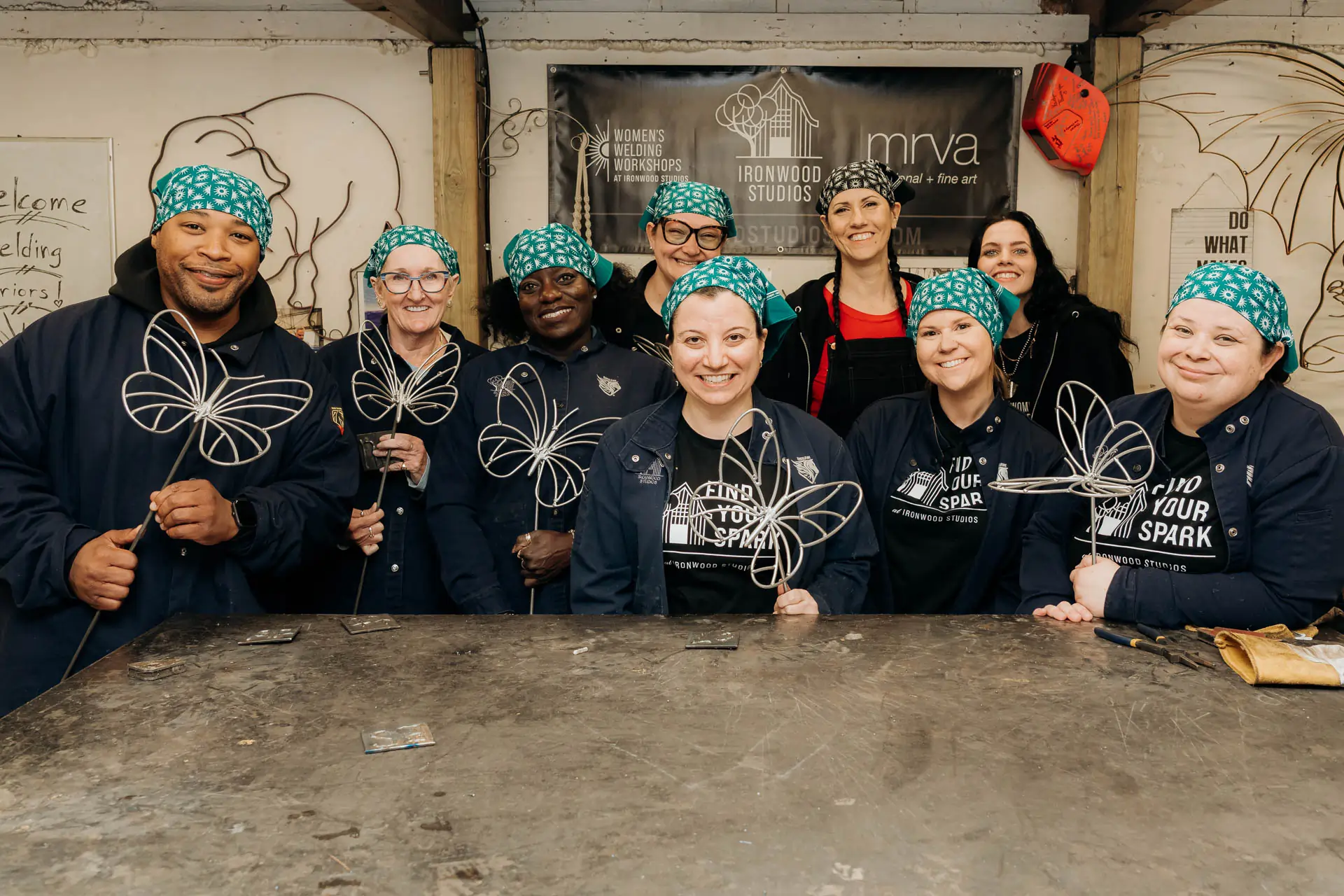 Workshop participants smiling and holding their finished welded butterfly sculptures